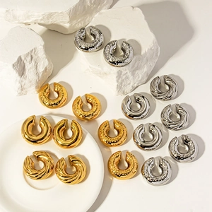 Ear cuff minimalisti svuotati in oro e argento con trame martellate e intrecciate a mano