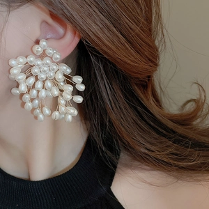 Detailed view of handcrafted pearl cluster earrings with elegant gold wire weaving
