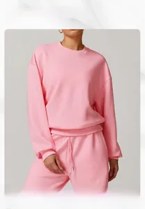 Détail d'un sweat-shirt rose à col rond et d'un pantalon de jogging porté par un mannequin