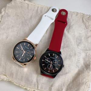 Detail of quartz sport watches with silicone bands and rhinestone markers on linen