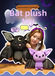 Detail of plush devil bat dolls featuring yellow moon and purple star embroidery