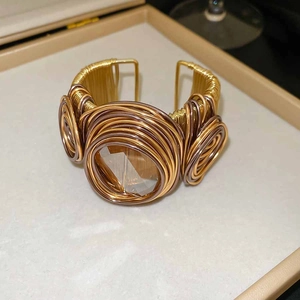 Détail du bracelet manchette torsadé orné d'un grand cristal clair à facettes au centre