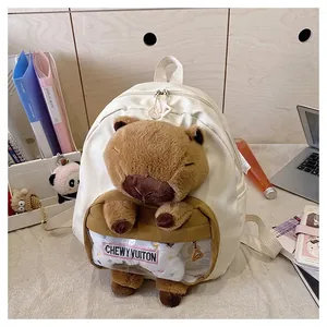 Detailed view of a white backpack featuring a plush capybara and a clear PVC pocket