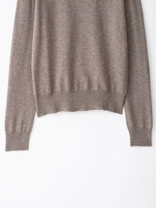 Detailed view of the ribbed hem and soft wool blend texture on this taupe knit sweater