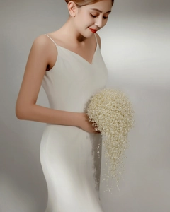 Detail of elegant bridal bouquet made of cascading pearls and white wedding accessories