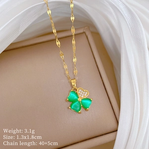 Detail of gold clover necklace with green opal and zircon heart on lip chain