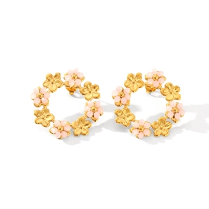 Détail des boucles d'oreilles fleuries en or 18 carats avec perles roses et acier