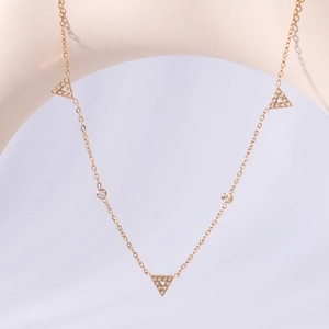 Minimalist gold triangle pendant necklace with pave zircons on elegant display stand