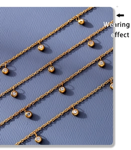 Detailed macro view of multi-layered gold anklet featuring bezel-set round zircon charms