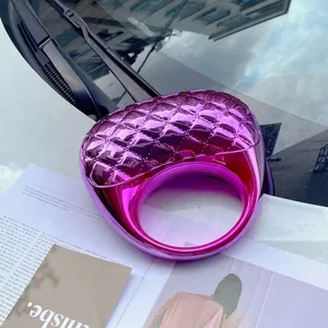 Macro detail of purple metallic acrylic ring with quilted lattice pattern on magazine