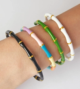 Detailed view of colorful bamboo style enamel bracelets with gold metallic accents