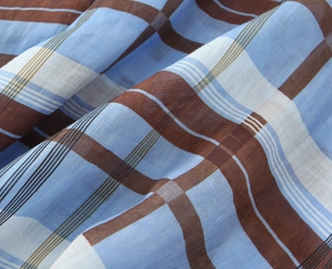 Close-up detail of ramie fabric with blue and tan plaid pattern texture