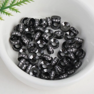 Macro shot of 18k gold-plated black spacer beads with zircons for DIY jewelry