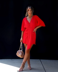 Détail de la robe rouge à col en V avec ceinture nouée et texture plissée élégante