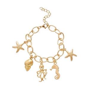 Gold ocean charm bracelet featuring starfish sea snail octopus and seahorse pendants