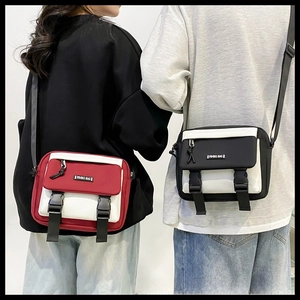 Detail view of the messenger bag showing color-blocking design and strap attachment