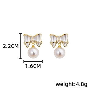 Detail view of bow pearl earrings with dimensions 2.2cm and 1.6cm showing stones and pearls