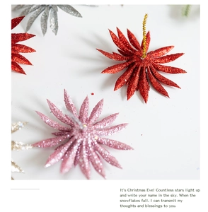 Close-up of glitter-coated Christmas flower decorations in red, pink, and silver colors