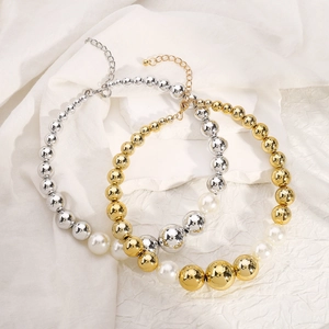 Detail showing gradient pearls and polished metal beads on a white textured background