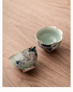 Détail de tasses en céramique à glaçure craquelée avec magnolia peint et bord doré