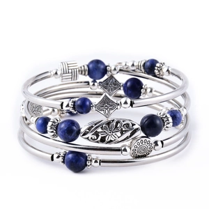 Close-up of bohemian layered silver bracelet with blue imperial stone beads and carvings