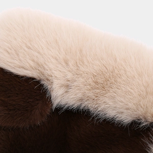 Close-up of soft cream and dark brown faux fur texture on a winter trapper hat