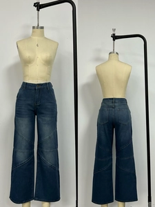 Detail view of high-waisted vintage wash jeans with curved panel stitching and rear pockets