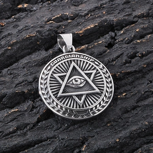 Macro shot of silver metal pendant featuring Masonic eye and hexagram on dark bark