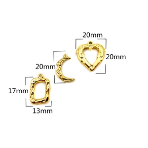 Detail of gold hammer-textured pendants in rectangle, crescent moon, and heart shapes