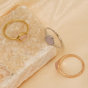 Gros plan de bagues en quartz rose irrégulières en finitions or, argent et or rose.