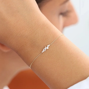 Close-up of minimalist gold-plated 925 silver bracelet with sparkling white crystal clusters
