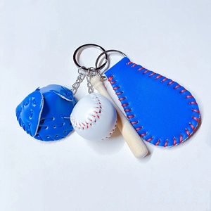 Detailed shot of a 3-piece baseball keychain set with blue glove, ball, and wood bat