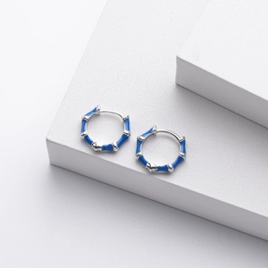 Detail showing blue enamel bamboo-shaped s925 silver earrings on a white stone base