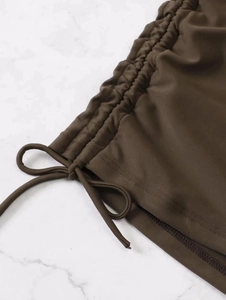 Detailed view of dark brown bikini fabric with side drawstring and ruched texture details