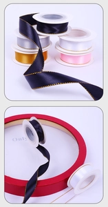 Detail view of double-sided satin ribbons with gold metallic edges on plastic spools