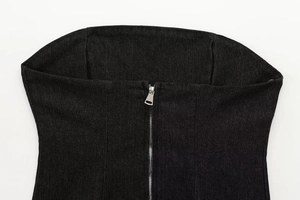 Dettaglio della cerniera in metallo argento su un top a tubo in denim nero con trama twill
