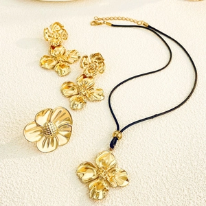 Détails à plat d'un ensemble de bijoux fleurs dorées avec collier et boucles