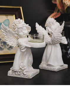 Detailed macro view of white resin angel wings and textured base of the candle holder