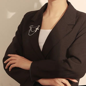 Silver cross brooch with mother of pearl pendant and double chains on black suit lapel