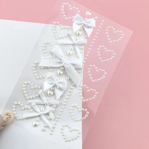 Detailed view of heart pearl stickers and white fabric bows for fairy eye makeup decoration