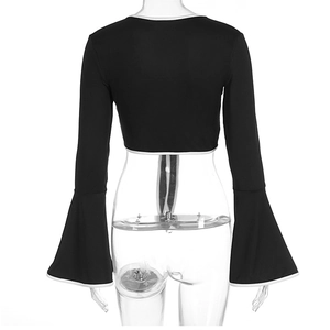 Detail view of the flared bell sleeves with white contrast trim on the black crop top