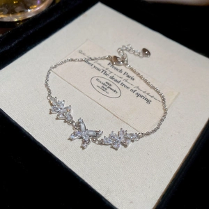 Detailed close-up of 18k silver plated floral and butterfly bracelet with shiny zircons