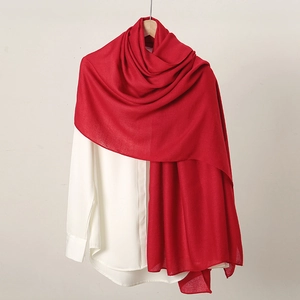 Detailed texture of red cotton linen scarf draped over a white shirt on a hanger