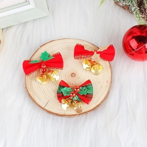 Three festive Christmas bows with golden bells on a wooden coaster for holiday decor