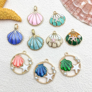 Flat lay of colorful enamel shell pendants with pearls for DIY jewelry making