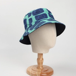 Detail view of mint green cotton bucket hat with blue pattern on a fabric display mannequin