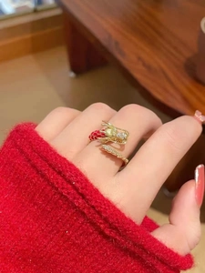 Detalle de anillo de dragón bañado en oro de 18K con escamas de esmalte rojo y circonitas