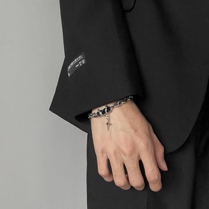 Close-up of titanium steel chain bracelet with black stone accents on a model sleeve