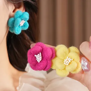 Boucles d'oreilles fleurs en résine bleu ciel avec texture laine et perles centrales