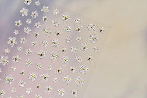 Detail shot of 3D embossed white flower nail stickers with gold bead centers